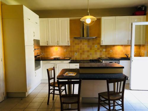 une cuisine avec des armoires blanches et une table et des chaises dans l'établissement Comfortable Paris 1, à Vitry-sur-Seine