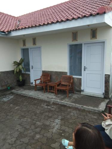 uma casa com duas cadeiras e uma mesa no exterior em BROMO B&B em Bromo