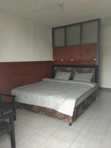 a bedroom with a large bed with a wooden headboard at BROMO B&B in Bromo