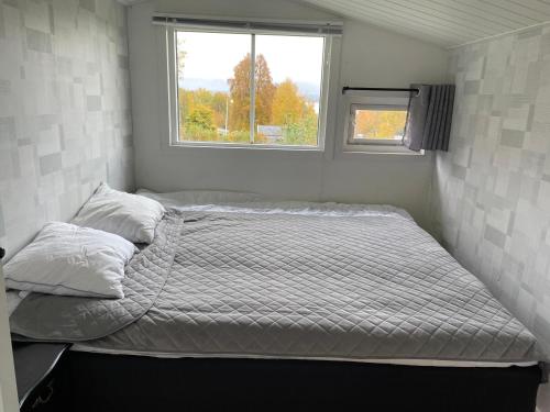 uma cama num pequeno quarto com uma janela em Two small Guest houses by lake rent out as One em Hjo