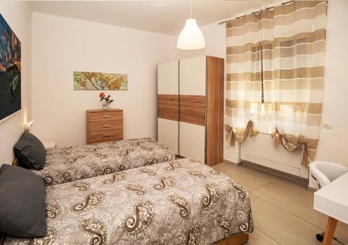 a bedroom with two beds and a dresser at Amantea Apartment THE NEW in Amantea