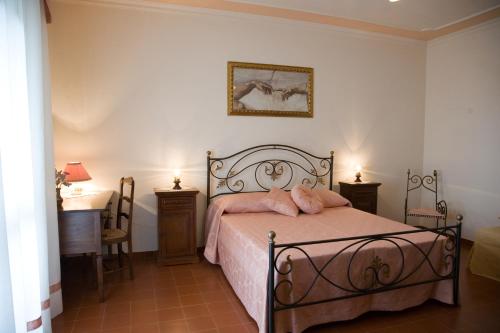 a bedroom with a bed with pink pillows on it at B&B Podere Ospedaletto in Bolsena