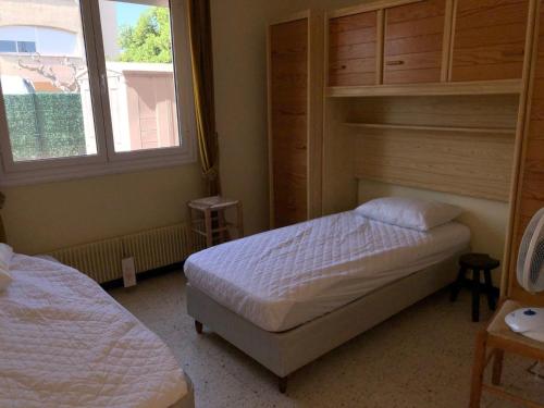 a bedroom with two beds and two windows at Villa T5 avec jardin, 100m plage, clim, WiFi, pour 8-10 pers, Le Barcarès - FR-1-81-524 in Le Barcarès