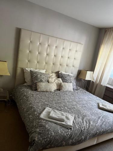 une chambre avec un grand lit avec une grande tête de lit dans l'établissement La Mirandole 3 pièces vue mer, au Golfe-Juan