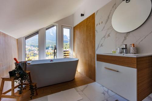 a bathroom with a large tub and a sink at The Bear House 2 in Buşteni