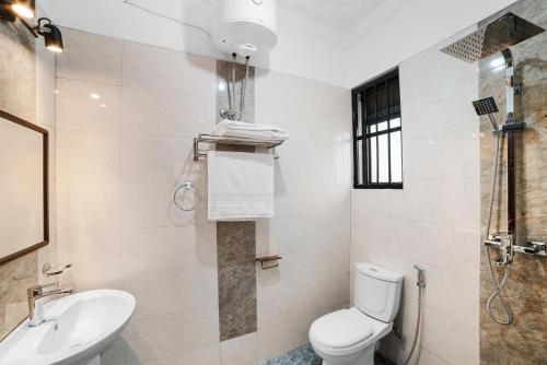 a bathroom with a toilet and a sink and a shower at Polo Apartments in Kampala