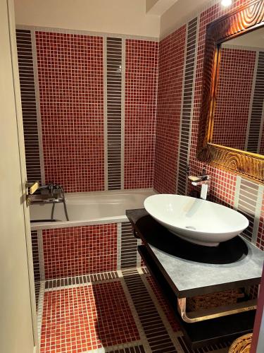 une salle de bain avec un lavabo, une baignoire et un miroir dans l'établissement La Mirandole 3 pièces vue mer, au Golfe-Juan