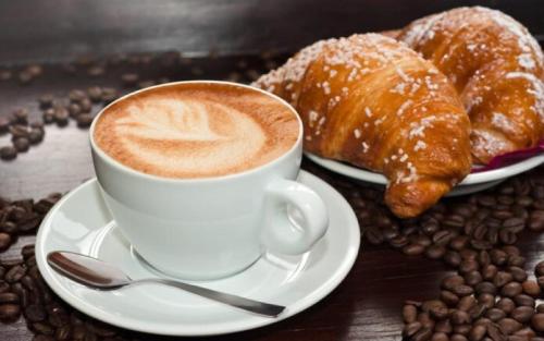 a cup of coffee and some pastries and coffee beans at Hotel Europa in Minori