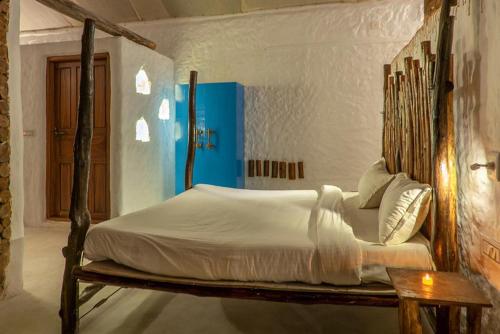 a bed with a wooden frame in a room at Deshadan Eco Valley Resort - An Eco friendly Mud House in Kanthalloor