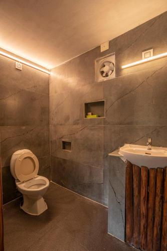 a bathroom with a toilet and a sink at Deshadan Eco Valley Resort - An Eco friendly Mud House in Kanthalloor