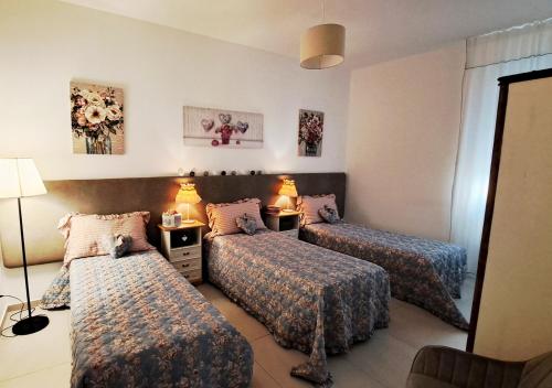 una camera d'albergo con tre letti e uno specchio di Amantea Apartment The Shabby-Chic ad Amantea