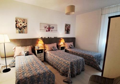 pokój hotelowy z 3 łóżkami i lustrem w obiekcie Amantea Apartment The Shabby-Chic w mieście Amantea