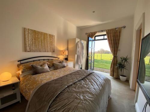 a bedroom with a large bed and a large window at Courtyard Cottage in Lockerbie