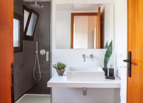 a bathroom with a sink and a mirror and a shower at Cala Bianca (The One&Only) in Castellammare del Golfo