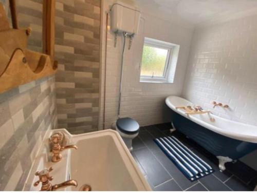 a bathroom with a tub and a sink at Valley Views in Llwyn-y-pia