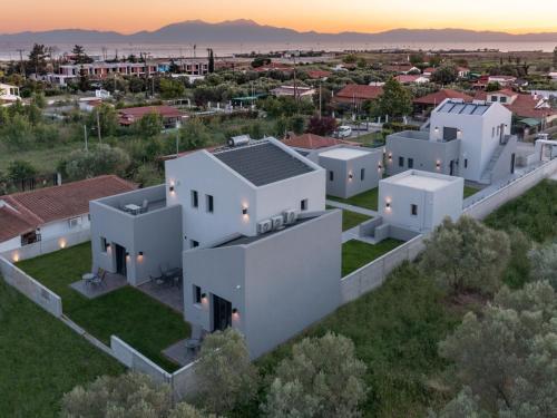 una vista aérea de una casa blanca con una ciudad en TheaSea Luxury Suites - Kallikrateia Halkidiki en Nea Kalikratia