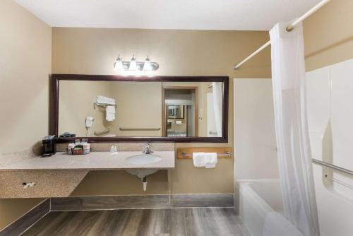 baño con lavabo y espejo grande en Quality Inn, en Upper Sandusky