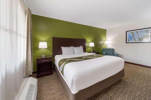 a bedroom with a large bed and a green wall at Quality Inn in Great Barrington