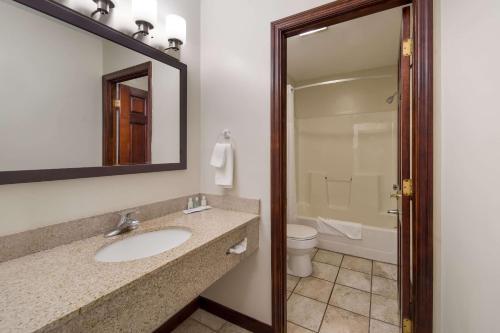 a bathroom with a sink and a toilet and a mirror at Quality Inn in Great Barrington