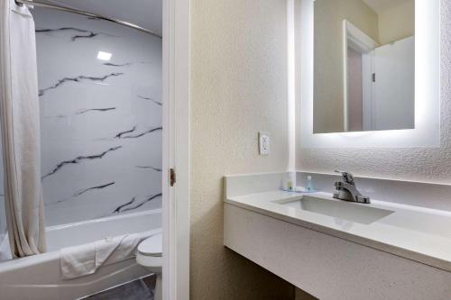 a bathroom with a sink and a toilet and a mirror at Quality Inn in Cameron