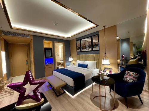 ein Schlafzimmer mit einem Kingsize-Bett und ein Wohnzimmer in der Unterkunft Planet Hollywood Thane in Thane