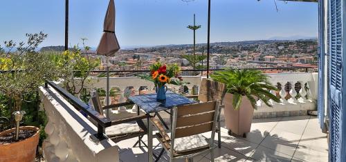a table with a vase of flowers on a balcony at Le Panoramic Boutique Hôtel in Nice