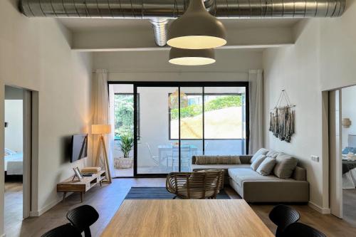 a living room with a couch and a table at Hauzify I Apartaments Sant Pau in San Pol de Mar