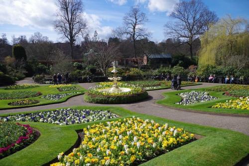 a garden with flowers and a fountain in the middle at Chandeliers 6 in Shrewsbury