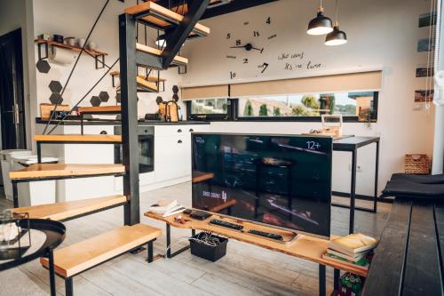 a living room with a large tv and a shelf at Zlatibor Wild nest Rabbit Lux in Zlatibor