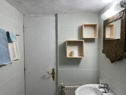 a white bathroom with a sink and a mirror at Monastiriako in Giannoudi