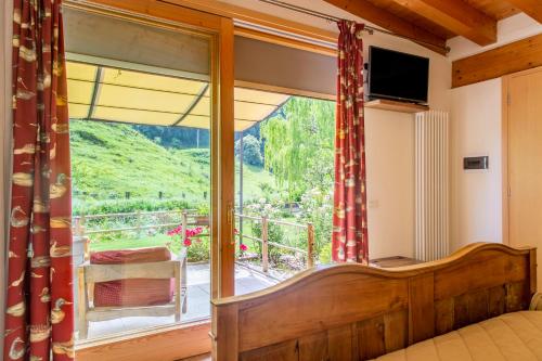 a bedroom with a bed and a large glass window at Hotel Calvi-Ristorante Mainor in Vittorio Veneto