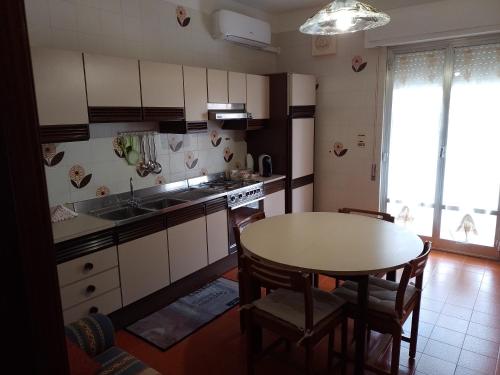 a kitchen with a table and a sink and a stove at Risveglio al Sole in Ragusa