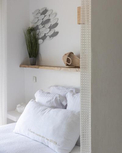 a bedroom with white walls and a bed with white pillows at Hotel de La Plage - Mahogany in Cassis