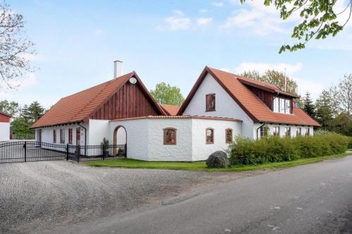 une grande maison blanche avec un toit marron dans l'établissement Birkevang The Silo - Rural refuge, à Faxe