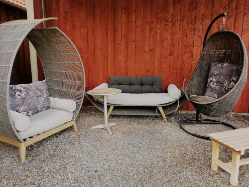 a patio with two chairs and a couch and a table at Birkevang The Silo - Rural refuge in Faxe