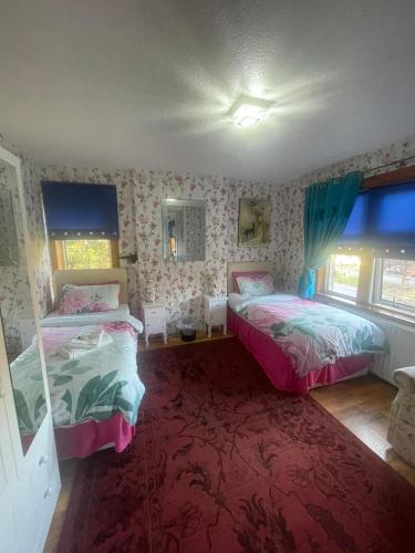 a bedroom with two beds and a red carpet at Redwood Lodge in Westbury