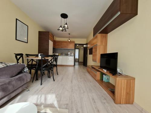 a living room and kitchen with a table and chairs at Apartments Ilarion in City Center in Varna City