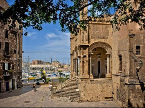 an old stone building with stairs on a street at AR Palace Hotel - Palermo in Isola delle Femmine