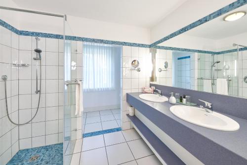 a bathroom with two sinks and a shower at Wein- und Landhaus S A Prüm in Bernkastel-Kues