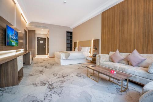 a hotel room with a couch and a bed at Grand Millennium Al Seef Basra in Al Başrah