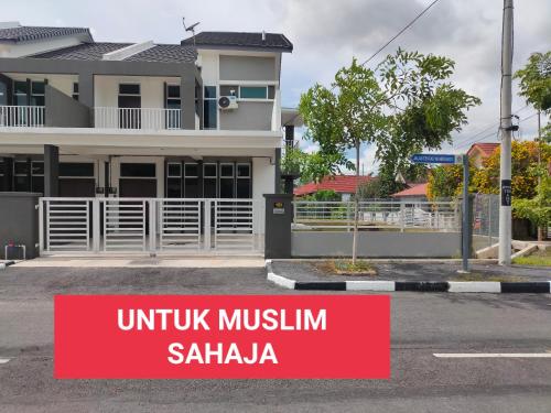a house with a red sign in front of it at Juliana Homestay in Jitra