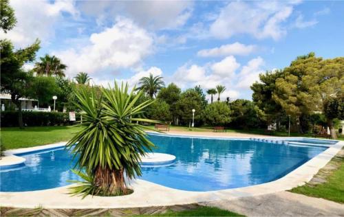 una piscina con una palmera en un parque en Santorini - Blue Dream Alacant - 1, en Gran Alacant