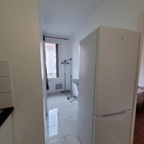 - un réfrigérateur blanc dans une cuisine avec fenêtre dans l'établissement Appart95 Saint-Brice CDG France, à Saint-Brice-sous-Forêt