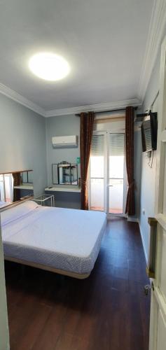a bedroom with a bed in a room with wooden floors at Habitación cerca del centro in Valencia