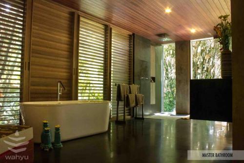 a bathroom with a bath tub in a room at Wahyu Private Peaceful Two Br Rustic Villa W Pool in Seminyak
