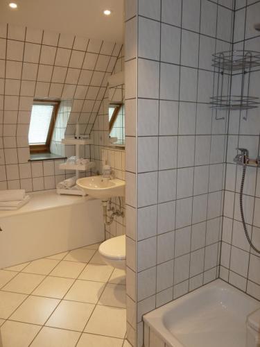 een badkamer met een wastafel, een toilet en een bad bij Helle 70 qm Ferienwohnung mit herrlichem Blick in Teningen