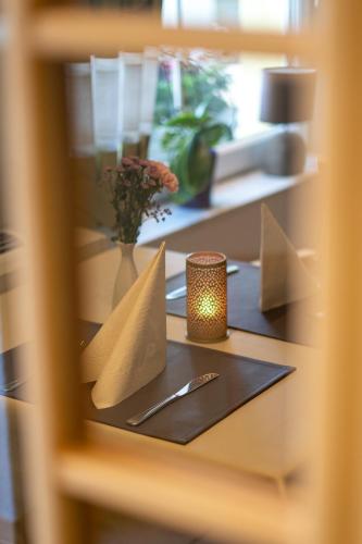 a table with a candle and a napkin on it at Warias Hotel am Geiseltalsee - Nähe Merseburg und Mücheln in Braunsbedra