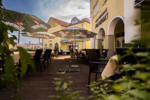 a patio with tables and chairs and umbrellas at Warias Hotel & Restaurant in Braunsbedra