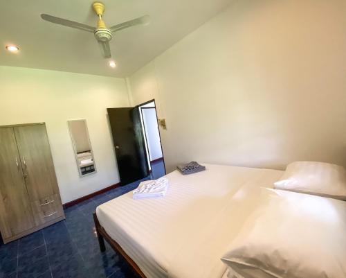 um quarto com 2 camas e uma ventoinha de tecto em Karon House 15C em Praia de Karon
