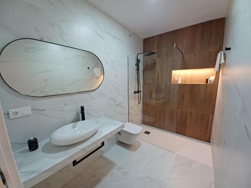 La salle de bains blanche est pourvue d'un lavabo et d'une douche. dans l'établissement La Camareta Alojamientos Turísticos Rurales, 